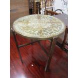 A folding brass topped occasional table