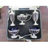 A silver five piece condiment set with blue glass liners by Hutton & Sons, Sheffield 1933