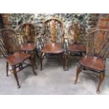 A set of four oak wheel back dining chairs and one matching carver with initials FR on the rear of