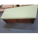 An early 20th century oak ottoman with an upholstered, hinged top and angled sides