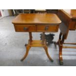 A modern yew pedestal, twin drawer lamp table, raised on splayed legs