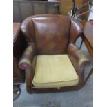 A modern brown leather and beige fabric upholstered armchair