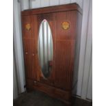 An Edwardian mahogany wardrobe having a single mirrored door and drawer below, standing on bracket