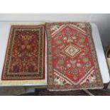 A Persian and a German mat, each with flora and foliage on a red ground, the largest 31" x 22"