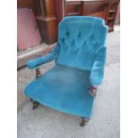 A Victorian gentleman's armchair with deep buttoned upholstery and overstuffed seat with ring turned