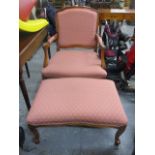 A modern yew finished, wing back armchair upholstered in a pink fabric, raised on cabriole