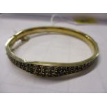 A silver gilt bangle inset with garnets