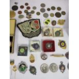 A mixed lot of silver and other metal badges, stick pins, a cloth badge and mixed coins