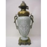 A late 19th century French pate sur pate and brass oil lamp of ovoid form, with twin loop and wreath