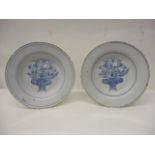 A pair of mid 18th century English Delft dishes, each decorated in blue and white with a basket of