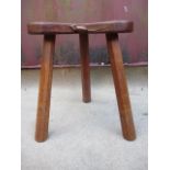 A Robert Thompson Mouseman carved oak stool with a kidney shaped, dished top, raised on octagonal,