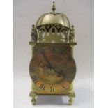 A 19th century French brass lantern clock having pierced fretwork below a bell and brass chapter