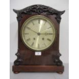 A Victorian mahogany cased mantle clock having an 8" silvered dial and Roman numerals in a carved,