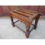 A Victorian walnut luggage stand with a slatted top, raised on turned, block legs, united by