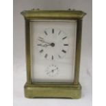 A late 19th/early 20th century French brass cased alarm carriage clock having a white enamel dial