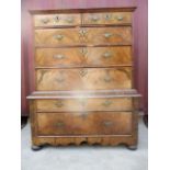 An early 18th century walnut chest on stand having a quarter veneered, crossbanded top over two