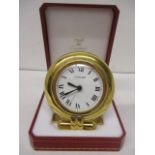 A Cartier quartz gilt metal cased, modern bedside clock having a circular case, white enamel dial