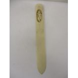 A late 19th century European ivory page turned, the handle carved with a recessed boy playing a