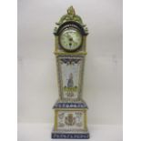 An early 20th century faience mantle clock in the form of a long case clock, having a pierced,