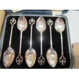 A set of six silver pierced and cased teaspoons, alongside a pair of cased silver shell salts with