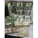 A collection of early 20th century postcards and cigarette cards, contained in twelve albums