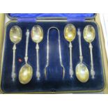 A set of six figural handled silver teaspoons with matching sugar tongs, cased