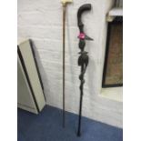 A Victorian bamboo walking stick with a bone handles and an African carved walking cane