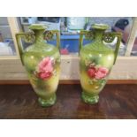 A pair of late Victorian/Edwardian continental porcelain vases with twin handles, decorated with