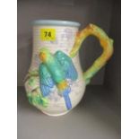 A Clarice Cliff jug with parakeet design and tree patterned handle, 9" h