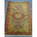 A Turkish hand woven rug with floral pattern, central medallion on a grey ground and triple guard