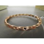 A 9ct rose gold bangle with twisted decoration and a pair of ear studs with butterflies, marked 375