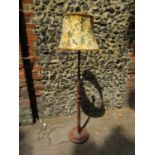 A mid 20th century turned wooden standard lamp with floral fabric shade