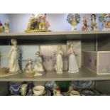 A group of four Lladro porcelain figurines to include one of a kneeling girl feeding medicine to a