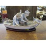 A Lladro porcelain figurine depicting an old man and a young boy fishing from a rowing boat, with