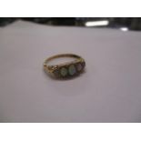 An 18ct gold ring set with five graduated opals, 1.8g