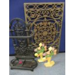 A wrought iron umbrella stand, two modern iron door stops and a wrought iron panel