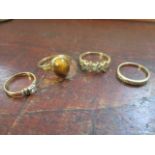 Four 9ct gold rings, two set with diamonds and the other coloured stones, and one set with a tiger's