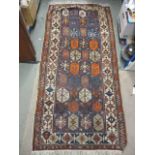 A Turkish rug with octagonal panels and arrow motifs, on a blue ground, 80" x 38"