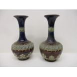 A pair of Doulton Lambeth pottery vases of ovoid form with a narrow neck, decorated with roundels