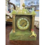 An early 20th century onyx mantle clock of architectural form with a gong strike movement, 12" h