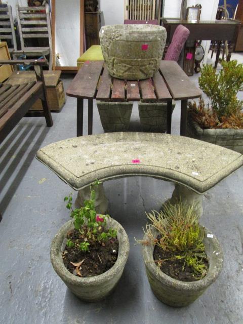 A stoneware garden bench, a pair of garden planters with plants, and a single stoneware planter of