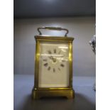 A late 19th/early 20th century brass cased carriage clock having a white enamelled dial and Roman