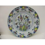 An 18th century polychrome Delft dish decorated with flowers and fruit, 13 1/4" dia A/F