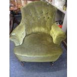 A Victorian armchair in a green velour fabric