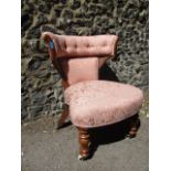 A William IV oak horseshoe shaped nursing chair with peach upholstery and later front turned legs