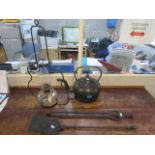A large cast iron kettle, a cast iron fire shovel and coal grabbers and a glass oil lamp with