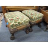 A pair of reproduction mahogany carved footstools on claw feet