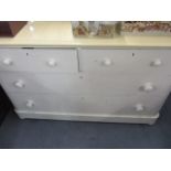 A cream painted low chest of two short and two long drawers, 30 1/2" h x 49 1/2" w