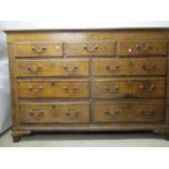 A George III mahogany crossbanded oak chest having a three quarter hinged top, over five facsimile