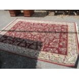 A pair of modern red ground floral rugs having multi guard borders and tasselled ends